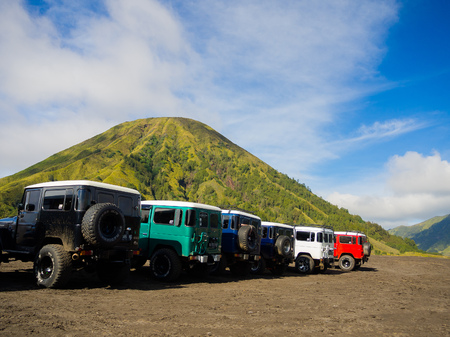 BROMO, INDONESIA - JULY 12, 2O17: Close up of many Jeeps parked in a row with the Mount Bromo in the horizont, the active mount Bromo is one of the most visited tourist attractions in East Java, Indonesiaのeditorial素材