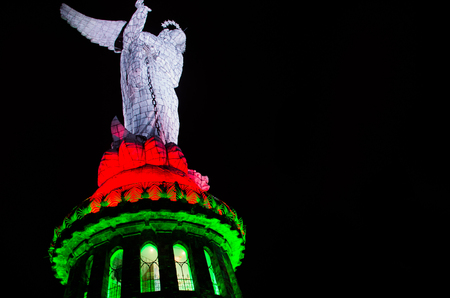 QUITO, ECUADOR - AUGUST 8, 2014: La Virgen de El Panecillo statue in the city center photographed at night view from below with a bright lights, red and green at nightのeditorial素材