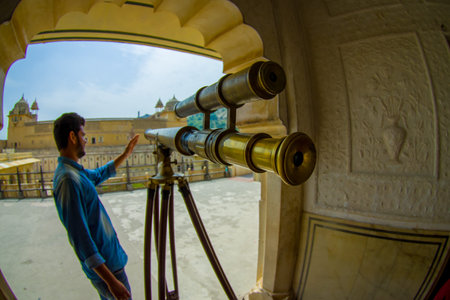 Amer, India - September 19, 2017: Unidentified man manipulating a golden telescope inside of the...