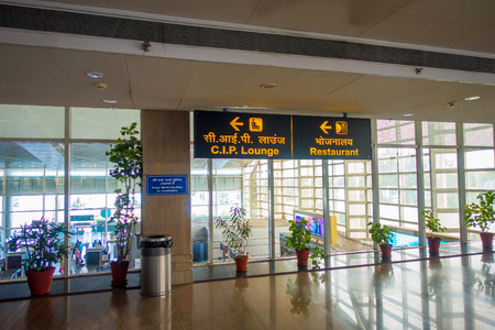 DELHI, INDIA - SEPTEMBER 19, 2017: Informative sign with yellow letters in black background of the restaurant and the lounge, in the exit of the International Airport of Delhi, India Gandhi International Airport is the 32th busiest in the worldのeditorial素材