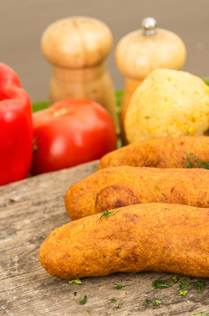 Muchin, an ecuadorian typical food with a blurred tomato and pepper, over a wooden tableの写真素材