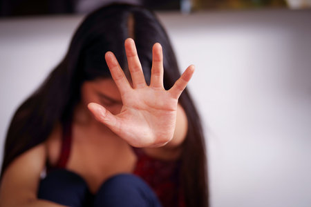Close up of a young woman pointing her open hand in front of her after being raped and suffering...