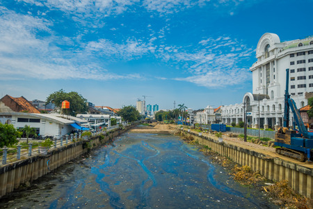 JAKARTA, INDONESIA - MAY 06, 2017: Charming water channel passing through Jakarta seen from bridge, residence buildings alongside. beautiful blue skyのeditorial素材