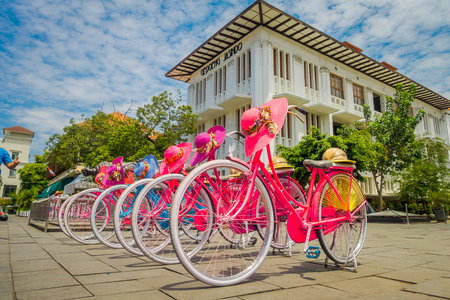 JAKARTA, INDONESIA - MAY 06, 2017: Row of pink bicycles with matching hats parked in front of Jakarta history museum on a beautiful sunny dayのeditorial素材
