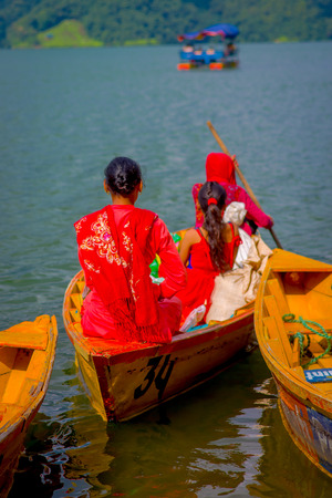 POKHARA, NEPAL - NOVEMBER 04, 2017: Unidentified group of women inside of wooden yellow boat at Begnas lake in Pokhara, Nepalのeditorial素材
