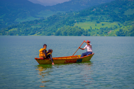 POKHARA, NEPAL - NOVEMBER 04, 2017: Unidentified couple enjoying the view with tourist guide paddling the boat in the Begnas lake in Pokhara, Nepalのeditorial素材