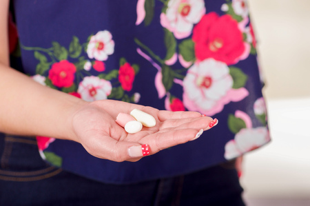 Close up of a woman hand, holding in her open hand a soft gelatin vaginal tablet or suppository, treatment of diseases of the reproductive organs of women and prevention of womens healthの写真素材
