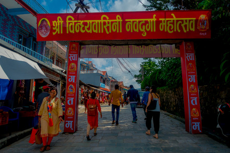 KATHMANDU, NEPAL - SEPTEMBER 04, 2017: Unidentified people walking in the morning market, under a red huge informative sign in Kathmandu, Nepal. The morning market is located near Annapurna temple at the center of Kathmandu, Nepal.のeditorial素材