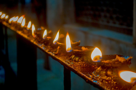 Burning candles in a row, darkness inside temple. Kathmandu, Nepal, Asiaの写真素材