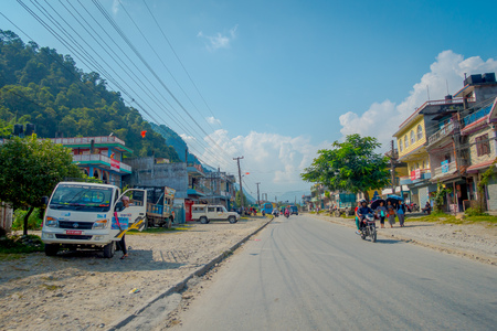 POKHARA, NEPAL, SEPTEMBER 04, 2017: Unidentified people walking and riding their motorbikes at outdoors in dowtown near the Pokhara Town in Nepalのeditorial素材