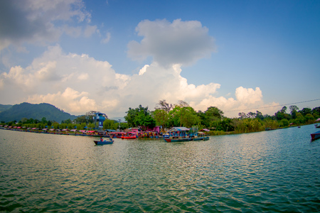 POKHARA, NEPAL - SEPTEMBER 04, 2017: Beautiful landscape of some buildings in the lakeshore with some boats in the Phewa tal-lake in Pokhara, Nepalのeditorial素材