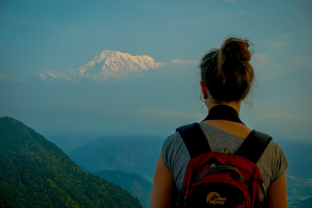 POKHARA, NEPAL, SEPTEMBER 04, 2017: Unidentified tourist at hilltop giving a back in the Sarangkot lookout point, taking pictures and enjoying the gorgeous view of the mountain Himalaya during sunrise at Sarangkot, Nepalのeditorial素材
