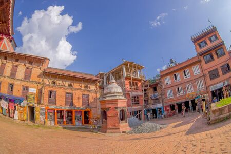BHAKTAPUR, NEPAL - NOVEMBER 04, 2017: Unidentified people walking in a plaza with some buildings in construction, and dome structure in Bhaktapur, Nepal, fish eye effect.のeditorial素材