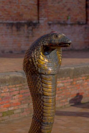 POKHARA, NEPAL - NOVEMBER 04, 2017: Close up of old rusted bronze snake statue located close to a temple in Pokhara, Nepal.のeditorial素材