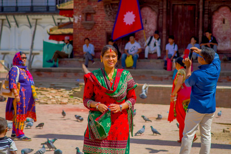 KATHMANDU, NEPAL OCTOBER 15, 2017: Unidentified nepalese woman wearing typical clothes posing for camera, in a Durbar square in a beautidul sunny day near old hindu temples in Kathmandu, Nepalのeditorial素材