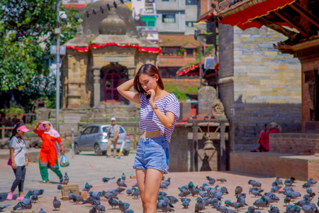 KATHMANDU, NEPAL OCTOBER 15, 2017: Unidentified nepalese woman posing for camera, in a Durbar square in a beautidul sunny day near old hindu temples in Kathmandu, Nepal.のeditorial素材