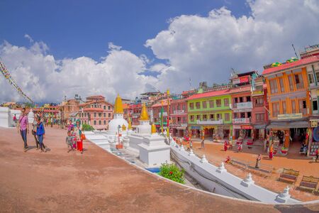 KATHMANDU, NEPAL OCTOBER 15, 2017: Unidentified people walking close to the heritage monument Boudhanath stupa and its colorful flags in daylight with bue sky, following full restoration after 2015 earthquake damage. Kathmandu, Nepal, fish eye effect.のeditorial素材
