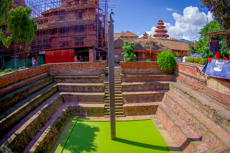 KATHMANDU, NEPAL OCTOBER 15, 2017: Outdoor view of artificial pond with green water with a carved pillar in the middle of the pond in Kathmandu, Nepalのeditorial素材