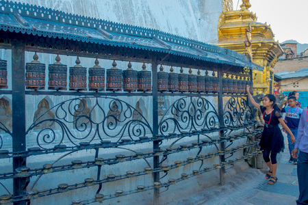 KATHMANDU, NEPAL OCTOBER 15, 2017: Unidentified people walking at outdoors close to Nepalese religious carvings and prayer wheels at Swayambhu Temple also known as the Monkey Temple in Kathmandu, Nepalのeditorial素材