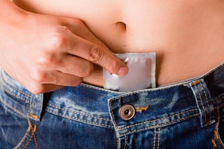 Close up of man hiding a condom inside of his private parts, a sign of a safety sexの写真素材