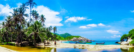 TAYRONA, COLOMBIA OCTOBER 20, 2017: Panoramic view of unidentified people enjoying the beautiful sunny day and swimming in the water, with some boats, Cabo San Juan, Tayrona Natural National Park, Colombiaのeditorial素材