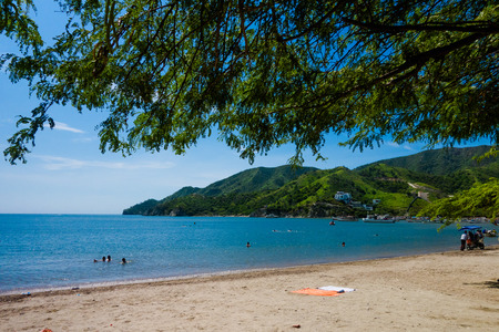 Beautiful outdoor view of Taganga, the caribbean coast with some tourists enjoying the sunny day in Colombiaの写真素材