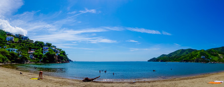 Beautiful panoramic view of Taganga, the caribbean coast with some tourists enjoying the sunny day in Colombiaの写真素材