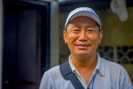 POKHARA, NEPAL - OCTOBER 06 2017: Portrait of Tibetan man posing for camera and wearing hat in Tashi ling village. Tashi Ling is one of the tibetan refugee camp in Nepalのeditorial素材