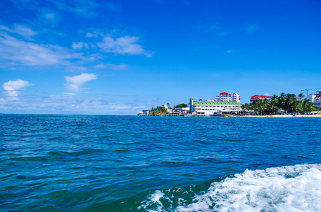 Beautiful view of some buildings in the horizont with a gorgeos blue water in San Andres Island during a sunny day in San Andres, Colombiaの写真素材