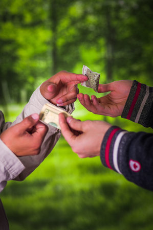 Close up of a man addict and dealer trafficking, addict with money buying dose from dealer with...