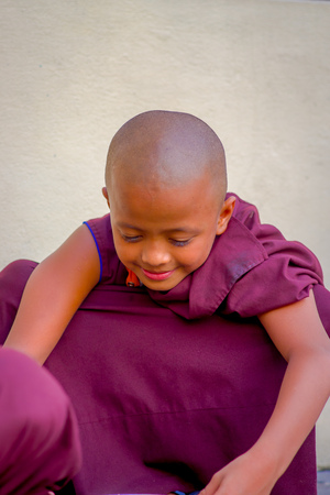 POKHARA, NEPAL - OCTOBER 06 2017: Close up of buddhist monk boy smiling at camera during lunch at the Tashi refugee settlement in Pokhara, Nepalのeditorial素材