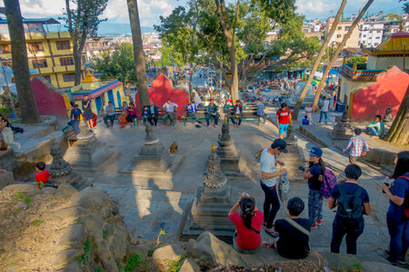 KATHMANDU, NEPAL OCTOBER 15, 2017: Unidentified people walking close to small stupas surrounded by...