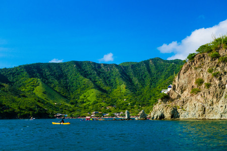 Unidentified tourists at the beautiful caribbean beach during a beautiful sunny day in Taganga, Colombiaの写真素材