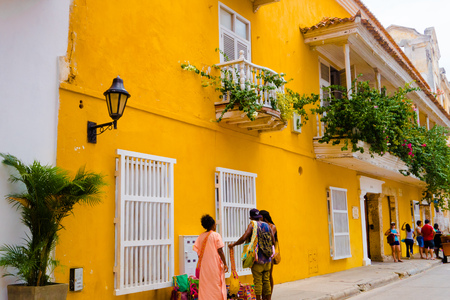 CARTAGENA, COLOMBIA 22, 2017: Unidentified people walking and buying handicrafts in Cartagena city street with colorful building of Cartagena Walled Cityのeditorial素材