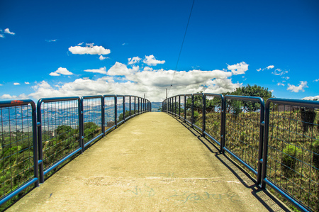 Outdoor view of pedestrian bridge over a road to visit the municipal dump in a beautiful day in the city of Quito, Ecuadorの写真素材