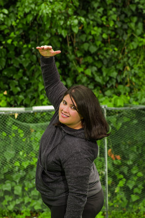 Young woman doing yoga exercise at outdoors, in a garden backgroundの写真素材