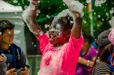 QUITO, ECUADOR- NOVEMBER, 28, 2017: Close up of cheerful little girl having fun and dancing at a foam party at Quito festivalのeditorial素材
