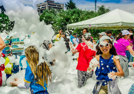 QUITO, ECUADOR- NOVEMBER, 28, 2017: Group of children having fun and dancing at a foam party at Quito festivalのeditorial素材