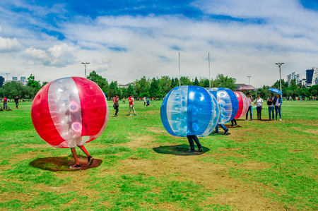 QUITO, ECUADOR - NOVEMBER 28, 2017: Young people playing soccer while is inside of giant inflatable ball in the Carolina Park during a festivalのeditorial素材