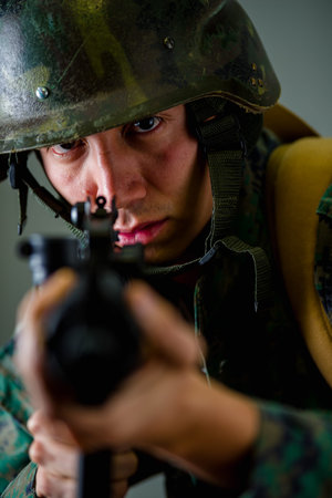 Portrait of young soldier holding in his hands a rifle, wearing a military uniform, selective focus...
