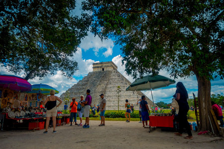 CHICHEN ITZA, MEXICO - NOVEMBER 12, 2017: Unidentified people buying beautiful and colorful handicrafts with a blurred image of Chichen Itza behind, one of the most visited archaeological sites in Mexico. About 1.2 million tourists visit the ruins every yのeditorial素材