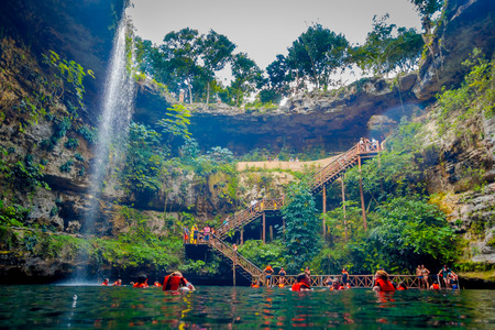 CHICHEN ITZA, MEXICO - NOVEMBER 12, 2017: Below view of unidentified people enjoying the day in the beautiful Ik-Kil Cenote pond with many people swimming, near Chichen Itza in Mexicoのeditorial素材