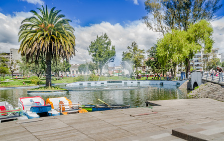 QUITO, ECUADOR - JANUARY 31, 2018: Unidentified people walking around of lagoon in the La Alameda Park with some buildings in the background. This is the oldest park in the city of Quitoのeditorial素材