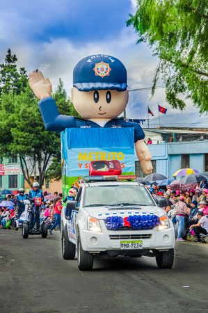 Quito, Ecuador - January 31, 2018: Outdoor view of a huge inflatable plastic puppet over a of metropolitan police car of Quito, during a parade in Quito, Ecuadorのeditorial素材
