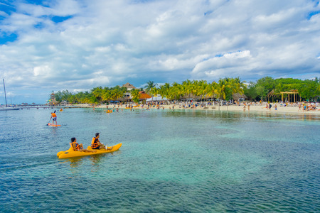 CANCUN, MEXICO - JANUARY 10, 2018: Unidentified people paddling in their kayack in a beautiful caribbean beach isla mujeres with clean and transparent water in Mexico, sun and palms. Tourism conceptのeditorial素材