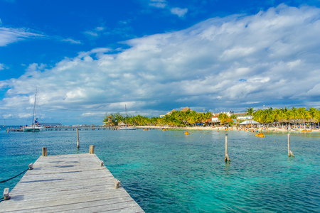 CANCUN, MEXICO - JANUARY 10, 2018: Unidentified people swimming in the shore and other paddling in their kayack in a beautiful caribbean beach isla mujeres with clean and transparent water in Mexicoのeditorial素材