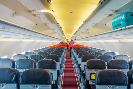 SINGAPORE, SINGAPORE - JANUARY 30, 2018: Indoor view of unidentified people acomodating their luggages in the compartments over the seats inside of Singapore Airlineのeditorial素材