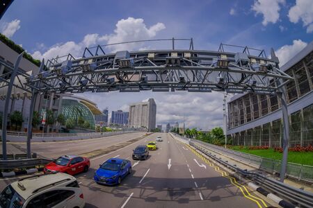 SINGAPORE, SINGAPORE - JANUARY 30. 2018: Outdoor view of some cars crossing under a metallic structure in a highway with a residential condominium building complex at Kallang neighborhood in the horizont of Singapore, fish eye effectのeditorial素材