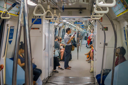 SINGAPORE, SINGAPORE - JANUARY 30, 2018: Indoor view of people in a rail commuters ride a crowded...