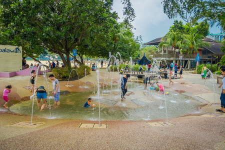 SINGAPORE, SINGAPORE - FEBRUARY 01, 2018: Beautiful outdoor view of children playing in the water with artificial fountains, close to the beach of Sentosa island in Singaporeのeditorial素材